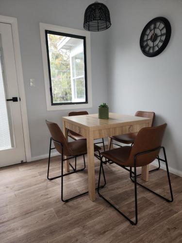a dining room table with chairs and a clock on the wall at Denman Motor Inn in Denman