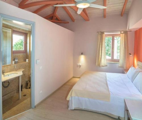 una camera da letto con un letto grande e un bagno di Villa Lakonia in Stoupa a Stoupa