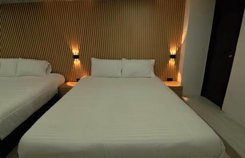 a large white bed in a small room with lights at Hotel Cordi in Guatavita