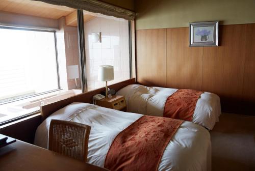 um quarto de hotel com duas camas e uma janela em Wakamatsu Hot Spring Resort em Hakodate