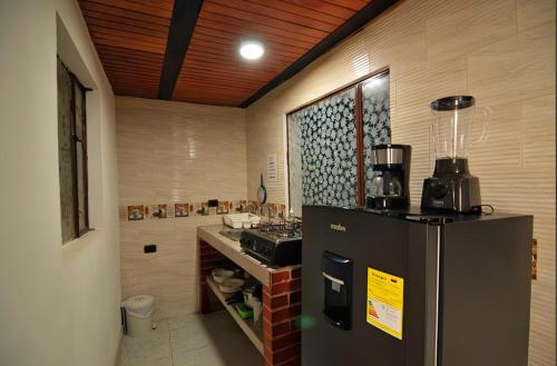 a kitchen with a refrigerator and a counter top at Hotel Cordi in Guatavita