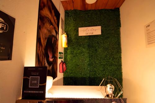 a room with a green wall with a sign on it at Hotel Cordi in Guatavita
