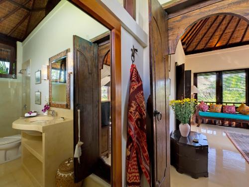 a bathroom with a sink and a toilet and a mirror at Villa Kakatua in Canggu