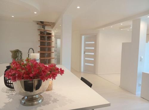 a vase with red flowers on a table in a room at Not Taking Guests in Eide