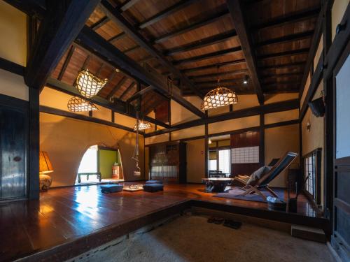 a large living room with wooden floors and chandeliers at Wanosato in Takayama
