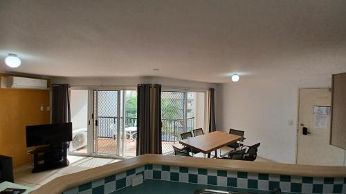 a living room with a table and a view of a patio at Blue Waters Apartments in Gold Coast