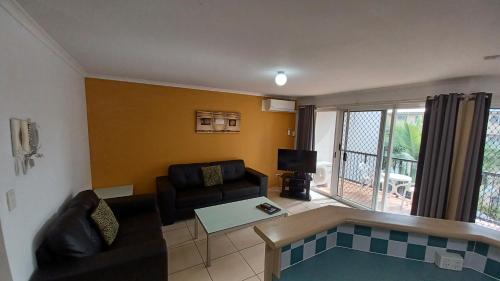 a living room with a couch and a table at Blue Waters Apartments in Gold Coast