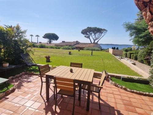 - une table et des chaises en bois sur une terrasse en briques dans l'établissement Studio climatisé avec piscine, parking, proche plage - Sainte-Maxime - FR-1-780-75, à Sainte-Maxime