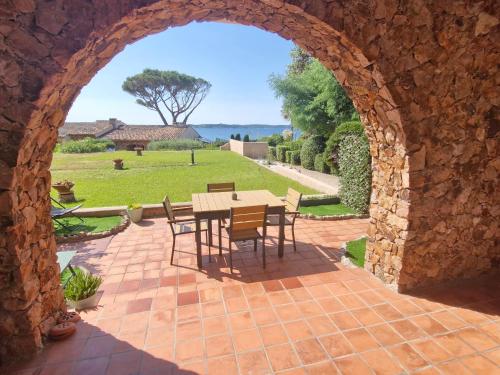 une arche en pierre avec une table et des chaises sur la terrasse dans l'établissement Studio climatisé avec piscine, parking, proche plage - Sainte-Maxime - FR-1-780-75, à Sainte-Maxime