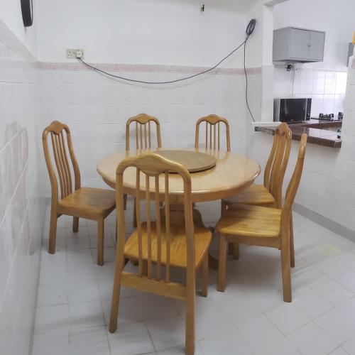 a wooden table and chairs in a kitchen at Nuha Kulim Hitech Homestay Islamic in Kulim