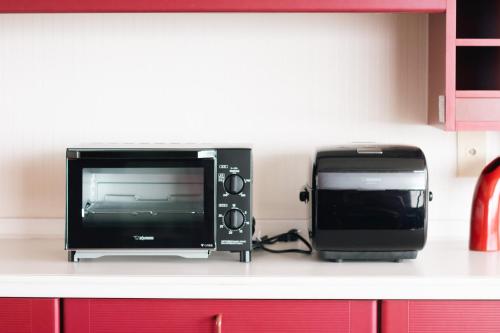 a microwave and a television on a kitchen counter at Gardenia in Aji