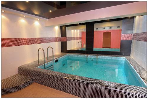 a bathroom with a jacuzzi tub with a mirror at Colibri Hotel in Novosibirsk