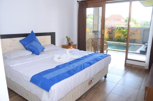 a bedroom with a bed with blue and white sheets at Bima Sakti House Canggu in Canggu