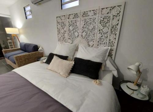 sypialnia z dużym białym łóżkiem z poduszkami w obiekcie "Koko Lodge" Lodge paisible avec terrasse, jardin et piscine w mieście Rémiré