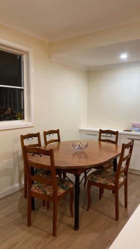 a dining room table with four chairs and a window at Spacious King Size Private Room Pet Friendly in Sydney