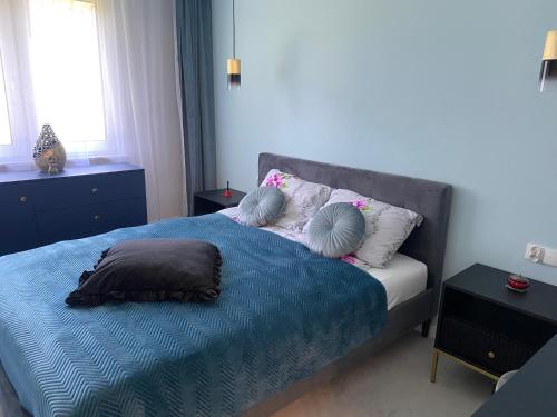 a bedroom with a bed with pillows on it at PaVoni Terazze Verdi Łeba in Łeba