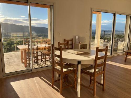 une salle à manger avec une table et des chaises et une grande fenêtre dans l'établissement Villa vue panoramique Ardeche, à Lussas