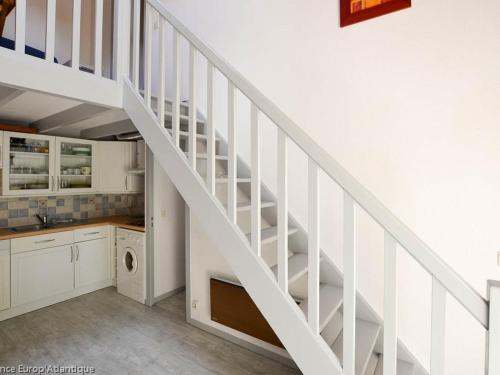 - un escalier blanc dans une cuisine avec un évier dans l'établissement Maison T3 bis La Palmyre - Terrasse, Wifi, Parking, Proche Mer et Commerces - FR-1-705-80, aux Mathes