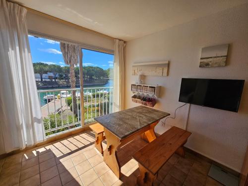 un salon avec une table et une grande fenêtre dans l'établissement Appartement 4 pers., 1 ch. - Saint-Cyprien avec Parking - FR-1-309-461, à Saint-Cyprien