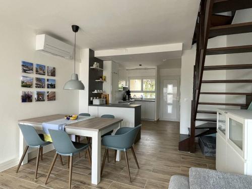 une cuisine et une salle à manger avec une table et des chaises dans l'établissement Villa rénovée à 50 m de la plage avec clim et wifi - FR-1-723-162, au Cap d'Agde