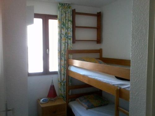 une chambre avec deux lits superposés et une fenêtre dans l'établissement T2 + cabine avec piscine, parking, proche commerces - FR-1-782-64, au Barcarès
