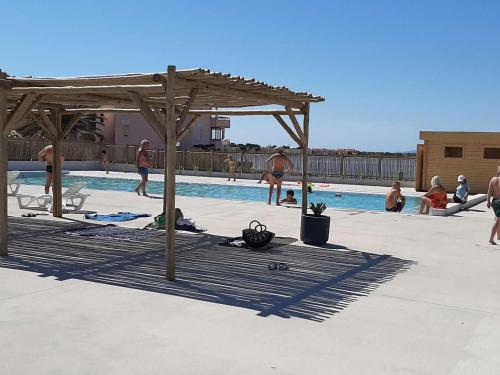 un groupe de personnes nageant dans une piscine dans l'établissement T2 + cabine avec piscine, parking, proche commerces - FR-1-782-64, au Barcarès