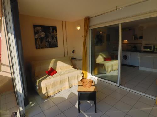 Cette chambre comprend un lit et une porte coulissante en verre. dans l'établissement Spacieux T2 avec terrasse et vue sur mer - FR-1-472A-307, à Sète