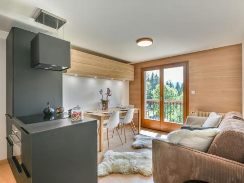 une cuisine et un salon avec un canapé et une table dans l'établissement Charmant T2 + cabine, proche pistes et centre, balcon, cheminée, WIFI, parking, 4-5 pers. - FR-1-685-80, aux Gets
