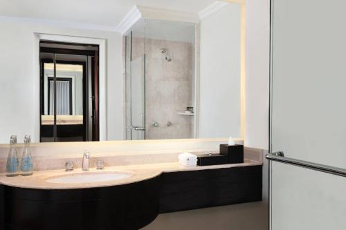 a bathroom with a sink and a large mirror at Sheraton Surabaya Hotel & Towers in Surabaya