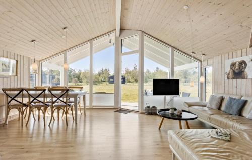 un salon avec un canapé, une table et des chaises dans l'établissement 3 Bedroom Lovely Home In Ålbæk, à Ålbæk