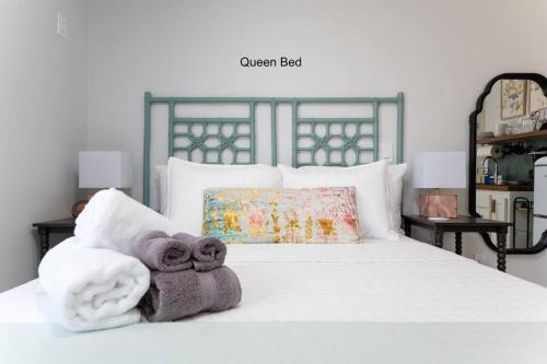 ジャクソンビル・ビーチにあるBe A Nomad - Stylish studio steps from the ocean!のタオルが敷かれた白いベッドのある寝室