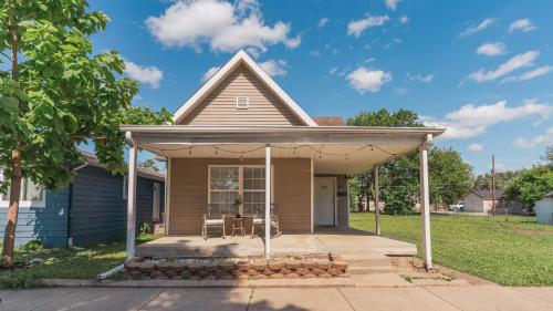 a small house with an awning on a porch at 5 mins to Speedway! Walk to Zoo, WR park, IUPUI! in Indianapolis