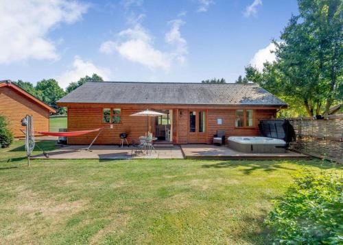 ein kleines Haus mit Hängematte im Hof in der Unterkunft Ford Farm Lodges in Aston Ingham