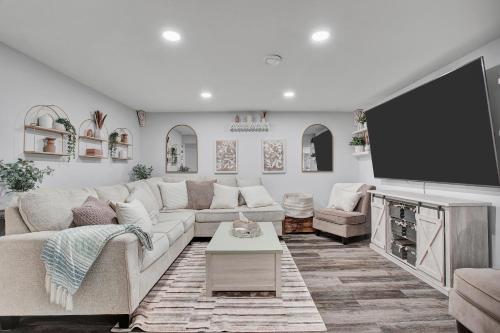 a living room with a large couch and a flat screen tv at Saskatoon 5 bedroom-Big Gatherings-Patio-BBQ-Games Room in Saskatoon
