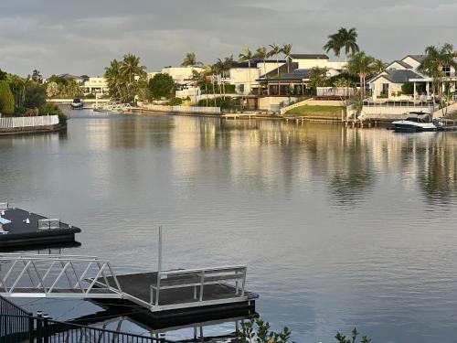 a boat is docked at a dock on a river at Waterfront BNB in Gold Coast