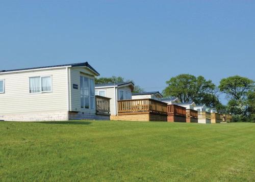 a row of houses on a grass field at Crofthead in Ayr