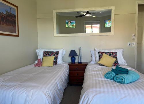 a bedroom with two beds and a mirror at Waterfront BNB in Gold Coast