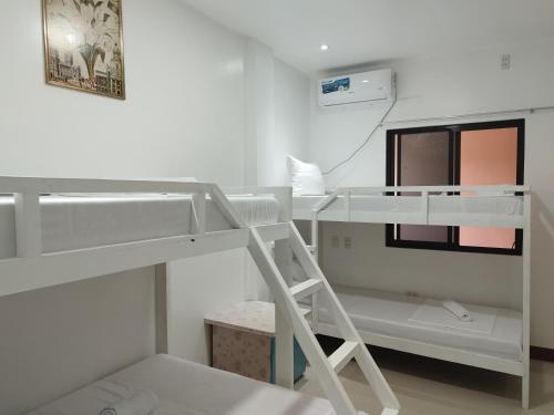 um beliche branco com uma escada num quarto em Ocean View Lodging House em Oslob