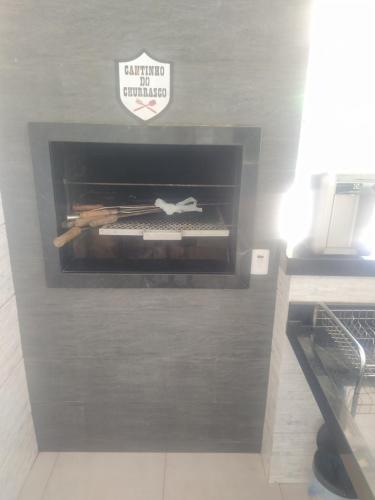 a room with a fireplace with a sign on it at Privacidade com Hidro, piscina em casa, garagem, tudo privativo, 2 banheiros, churrasqueira e pátio amplo exclusivos, insira 3 hóspedes e abrimos 2 quartos com ar, já 5 hóspedes para 3 quartos com ar in Sorriso