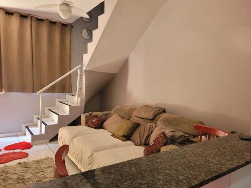 Una sala de estar con un sofá y una escalera. en Sobrado de condominio Praia Grande VilaTupi com 2 dormitorio, en Praia Grande