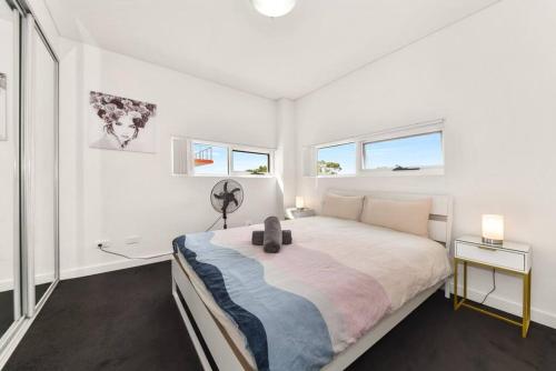 MerrylandsModern Luxury 3 Bedrm Apt Close to Parramatta, CBD的白色卧室设有一张大床和两个窗户