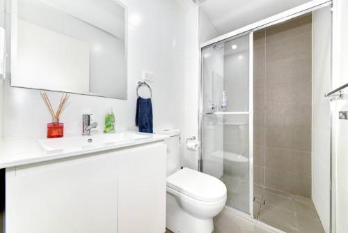 MerrylandsModern Luxury 3 Bedrm Apt Close to Parramatta, CBD的带马桶和淋浴的白色浴室
