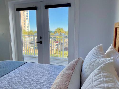 ein Schlafzimmer mit einem Bett und einem großen Fenster in der Unterkunft Be A Nomad - Oceanview villa 100yds to ocean in Jacksonville Beach