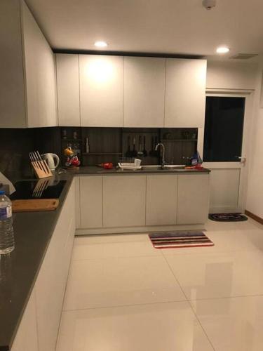 a kitchen with white cabinets and a black counter top at Luxury penthouse , Nilaveli, Srilanka in Nilaveli
