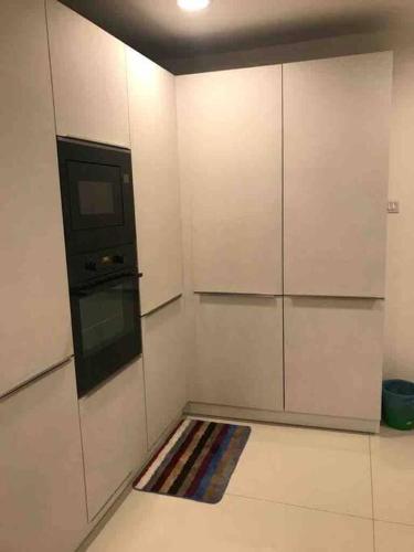 a kitchen with white cabinets and a rug on the floor at Luxury penthouse , Nilaveli, Srilanka in Nilaveli