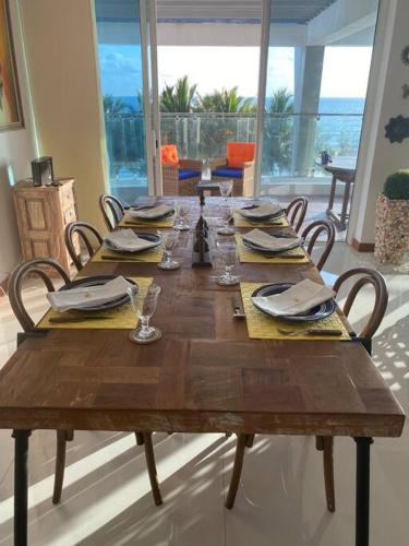 a wooden table with chairs and plates and napkins at Luxury penthouse , Nilaveli, Srilanka in Nilaveli