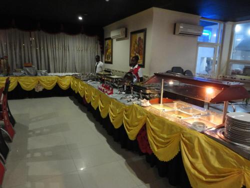 a buffet line in a restaurant with people preparing food at Urban Rose Hotel & Apartments in Dar es Salaam