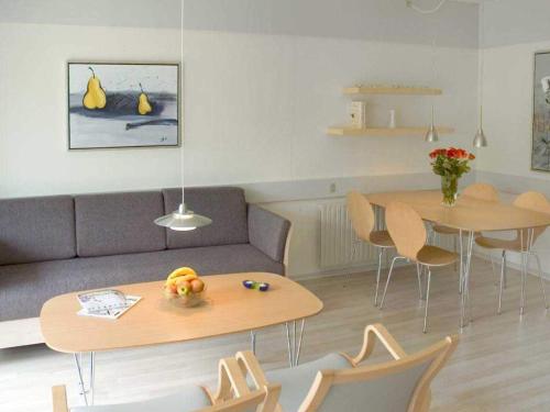 a living room with a couch and a table and chairs at 6 person holiday home in Hasle in Hasle