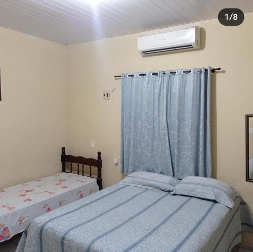 巴雷里尼亚斯Pousada Tia Cota的一间卧室，配有两张床和一扇窗户