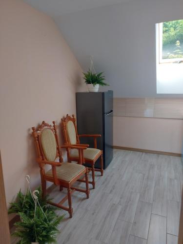 a kitchen with three chairs and a black refrigerator at DAR-KAJ MIESZKANIE nr 2 in Radzyń Chełmiński